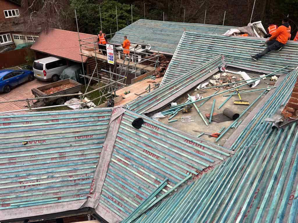 This is a photo of a large re-roof being carried out by KAM Roofing Askern, there are multiple sections of pitched roofs adjoining to a central flat roof
